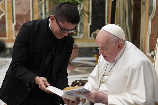 Pope Francis autographs a book