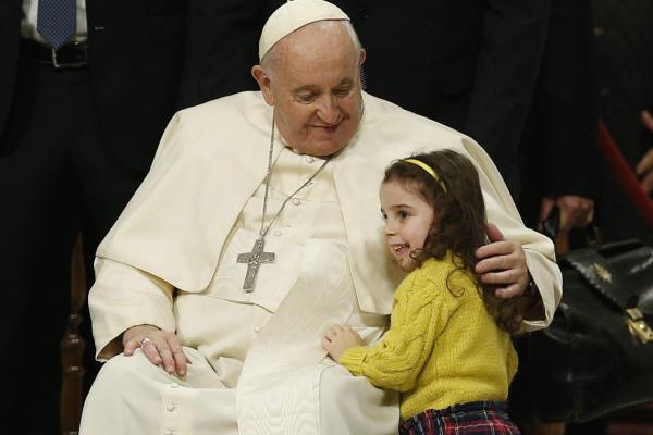 Pope Francis embraces a girl in St. Peter's Basilica