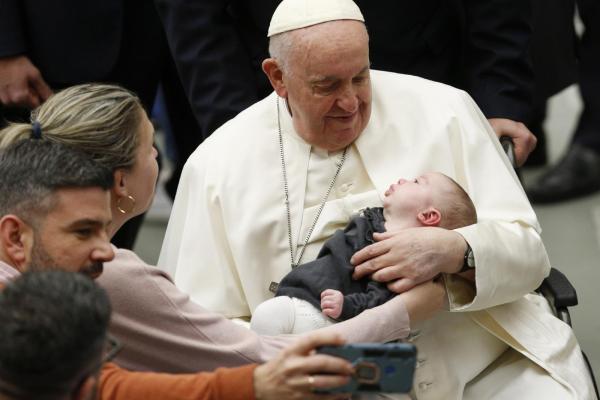Pope Francis holds a baby at his general audience