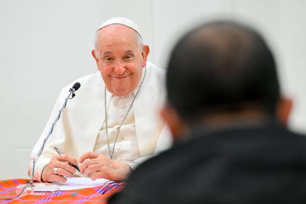 Pope Francis smiles during a meeting with priests.