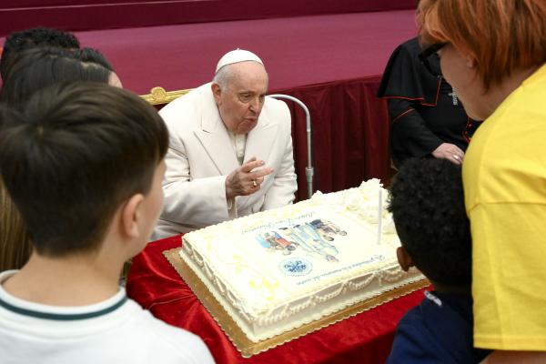 Pope Francis blows out the candles on his birthday cake during an audience with children assisted by the Vatican's pediatric clinic in the Paul VI Hall Dec. 17, 2023, his 87th birthday. (CNS photo/Vatican Media)