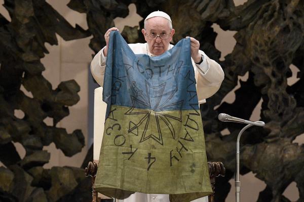 Pope Francis holds up a Ukrainian flag
