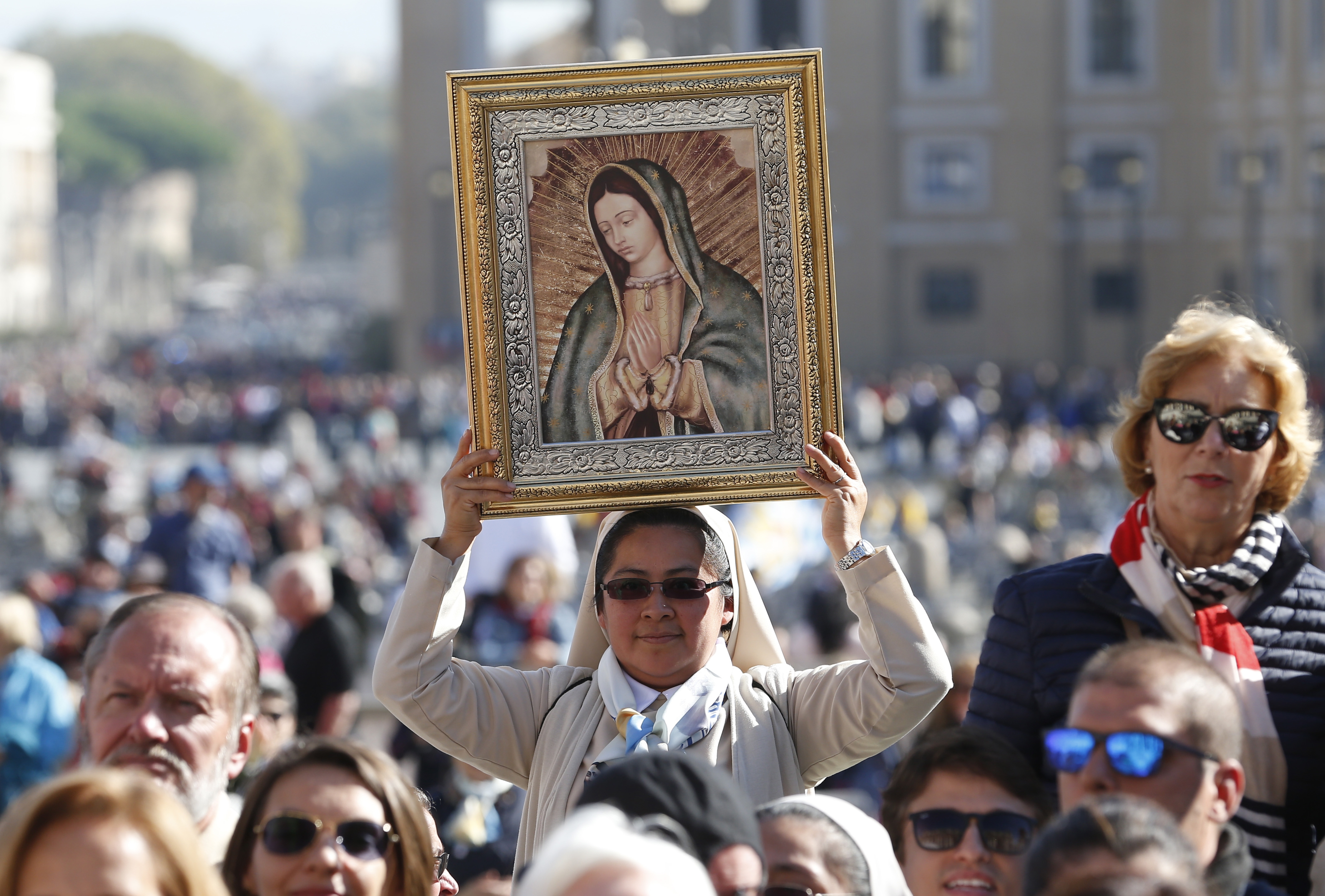 A religious sister holds an image of Our Lady of Guadalupe.