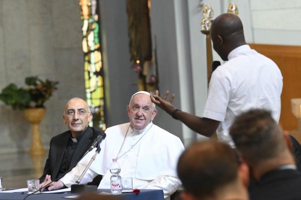 Pope Francis listens to a question during a meeting with priests ministering